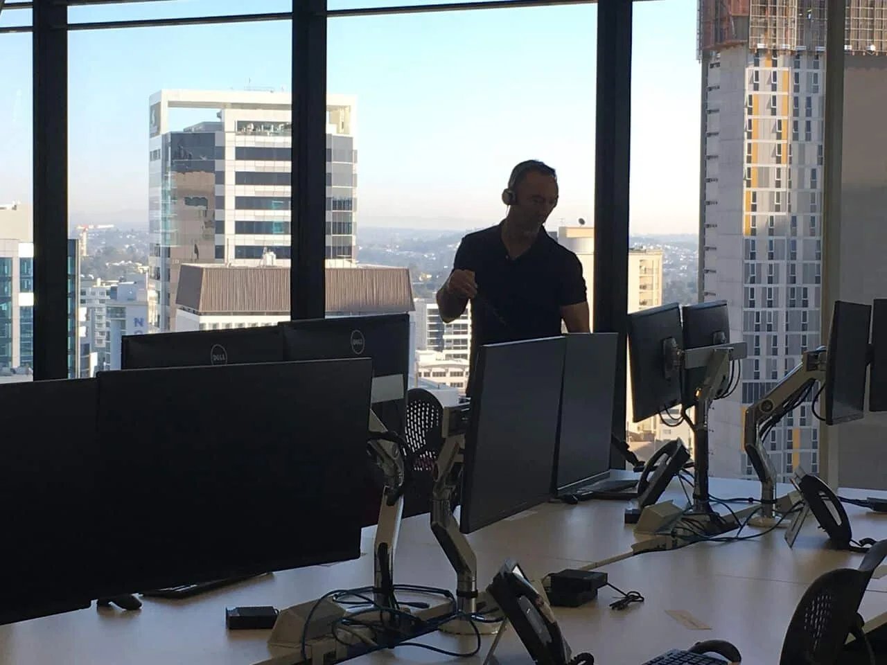 Technician sweeping an open-plan office with a city view